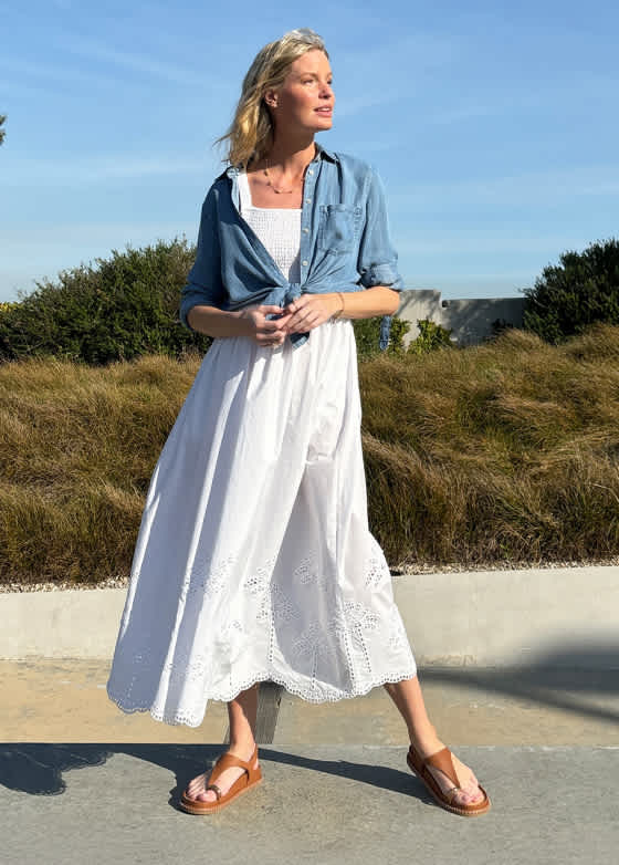  Model wearing Stitch Fix women’s clothing, including: a white eyelet midi dress styled with a cropped denim jacket and sandals.