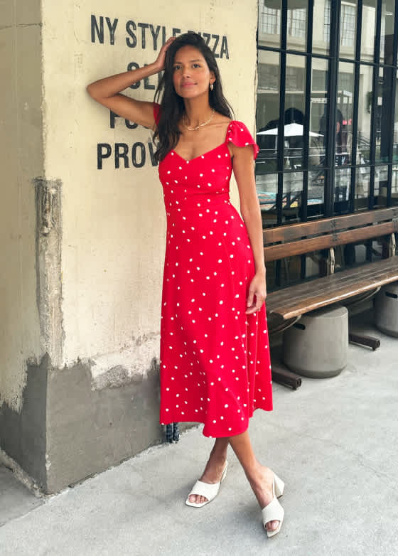  Model wearing Stitch Fix women’s clothing, including: a red off-the-shoulder midi dress with white floral print, paired with platform sandals.