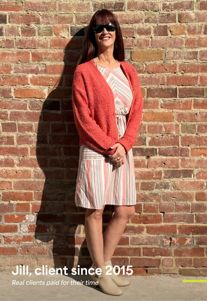Jill   Client Jill wears Stitch Fix women’s clothing including: a striped sleeveless dress with a coral cardigan and neutral ankle boots, standing in front of a brick wall. Text reads: “Jill, client since 2015. Real clients paid for their time.”