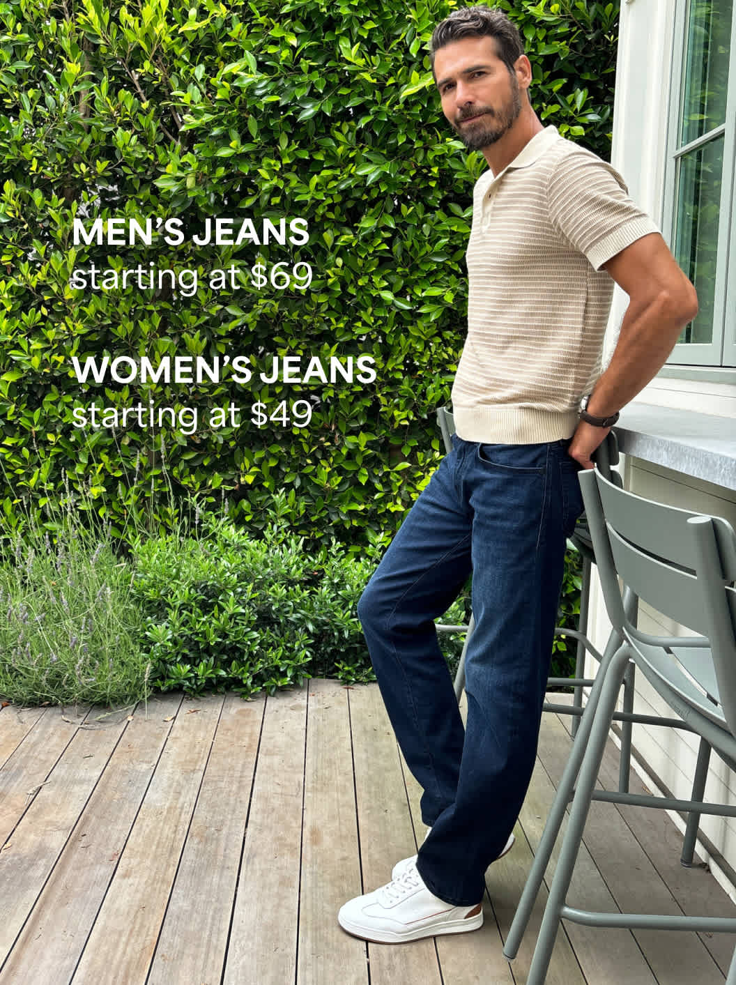 Men’s polos – A man in a light polo shirt and dark blue pants leans casually against a railing outside. Text reads “Men’s jeans starting at $69. Womens Jean's starting at $49"”
