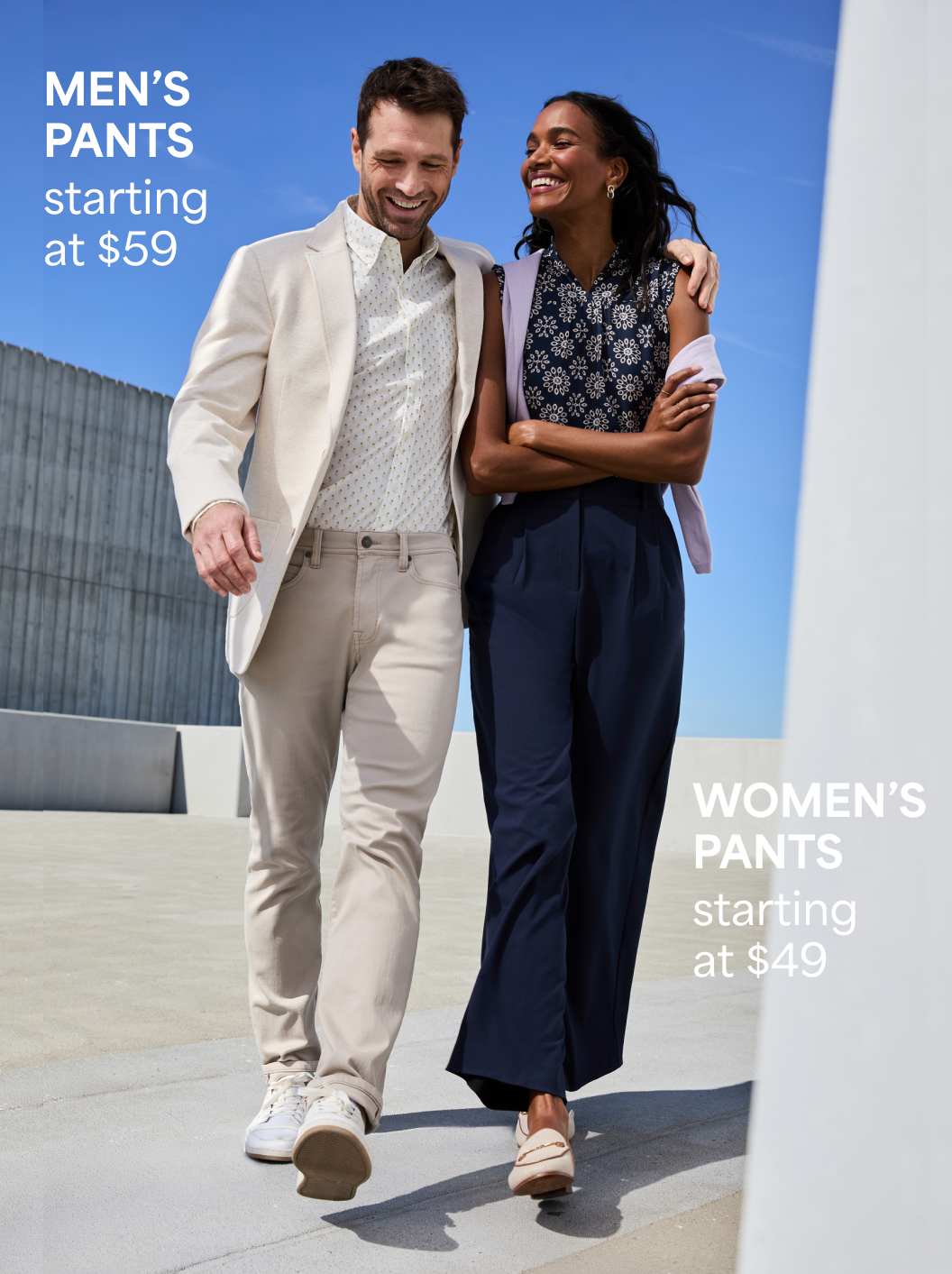 Men’s pants – A man in a light beige suit jacket and pants walks alongside a woman in a navy top and pants. Text reads “Men’s pants starting at $59.”