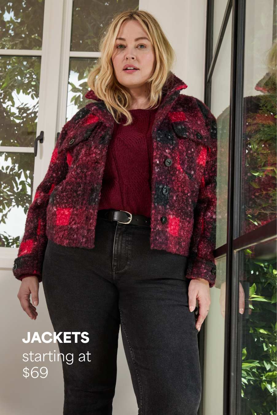 Stitch Fix women’s image showing a woman in a red-and-black plaid sherpa jacket with dark jeans, standing by a window. Text reads: “JACKETS starting at $69.”