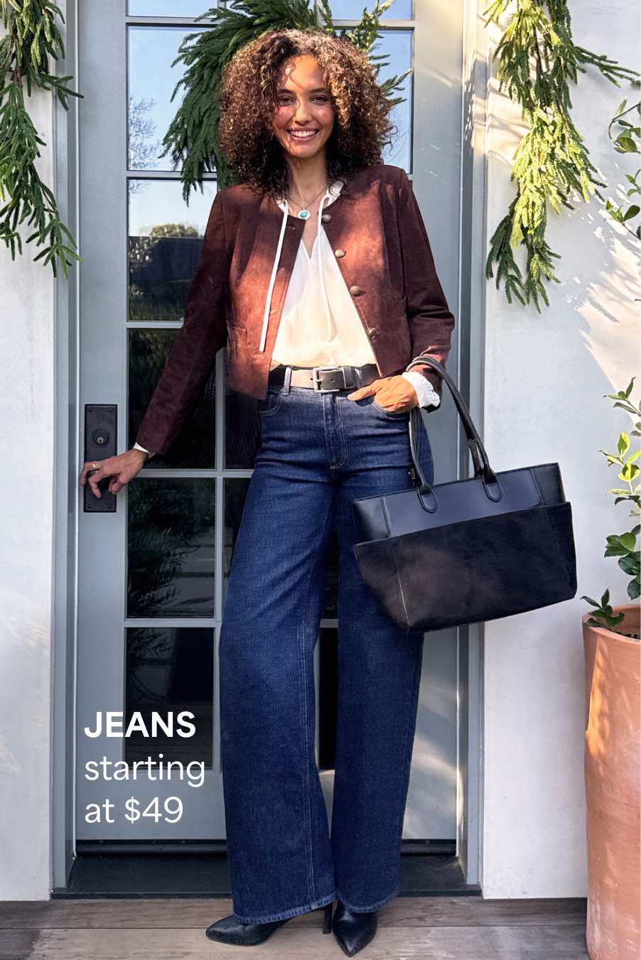 Stitch Fix women’s look featuring a woman wearing a burgundy jacket, white blouse, and dark-wash flared jeans while holding a black tote bag. Text reads: “JEANS starting at $49.”
