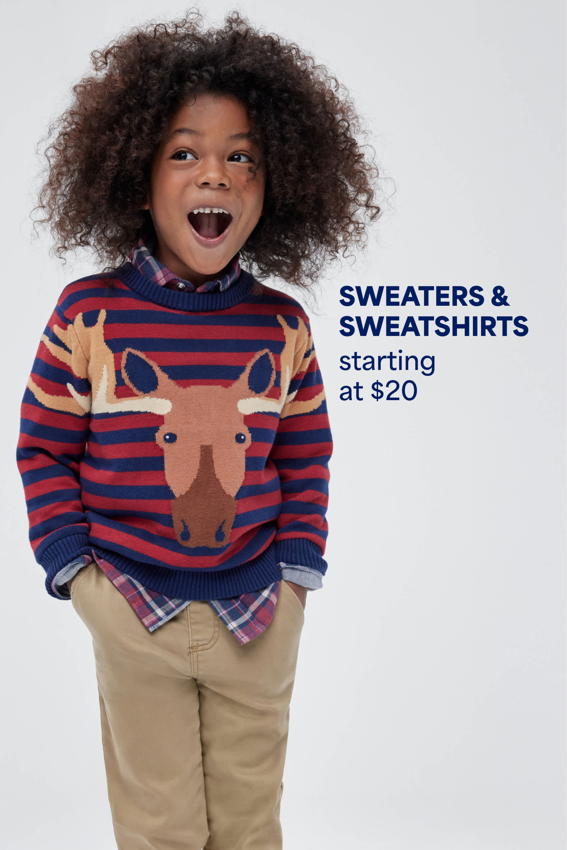 Stitch Fix Kids image showing a happy boy in a red and navy striped sweater with a moose design, layered over a plaid shirt and khaki pants. Text reads: “SWEATERS & SWEATSHIRTS starting at $20.”