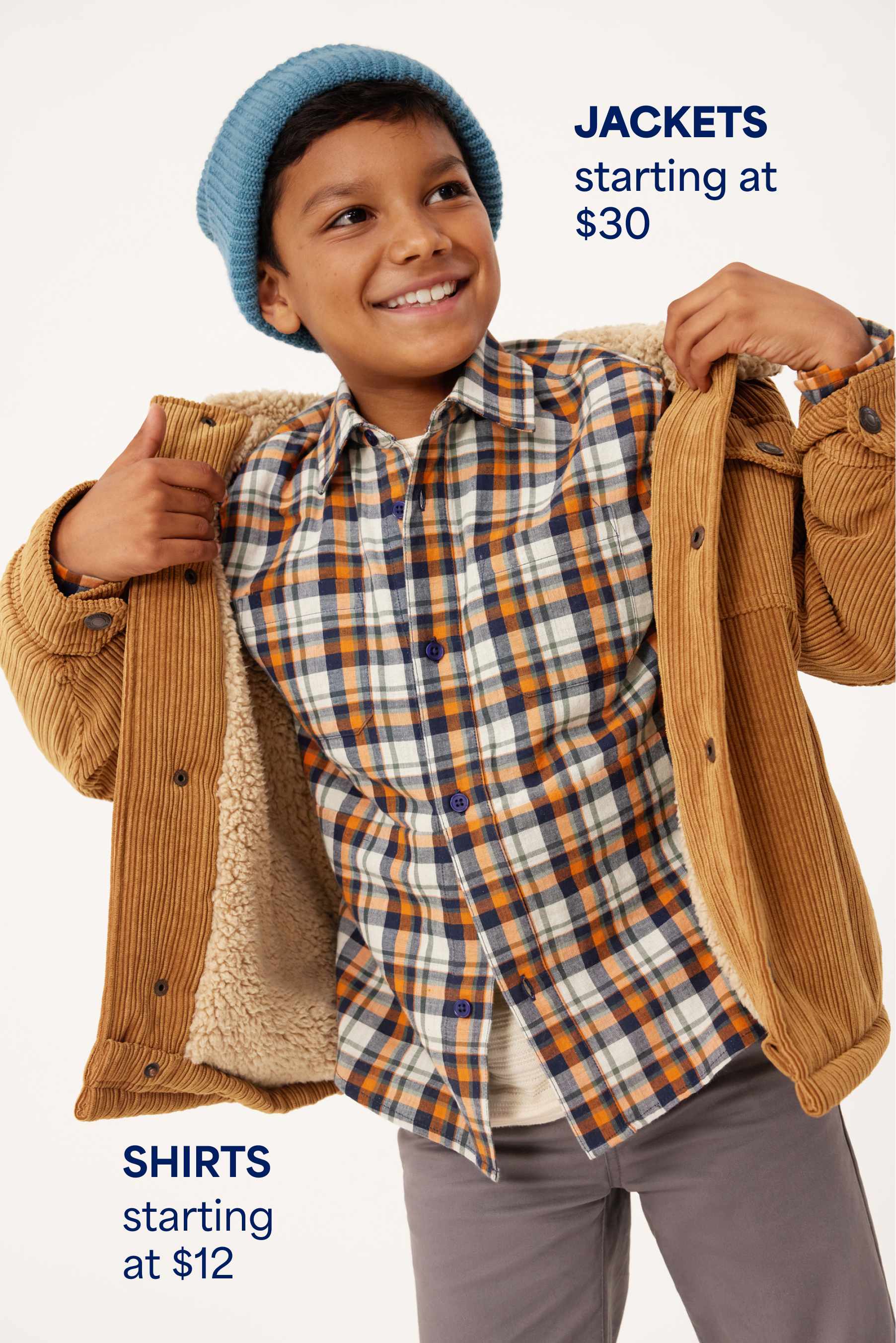 Stitch Fix Kids image of a boy smiling while putting on a tan corduroy jacket over a plaid shirt and gray pants, with a blue beanie. Text reads: “JACKETS starting at $30” and “SHIRTS starting at $12.”