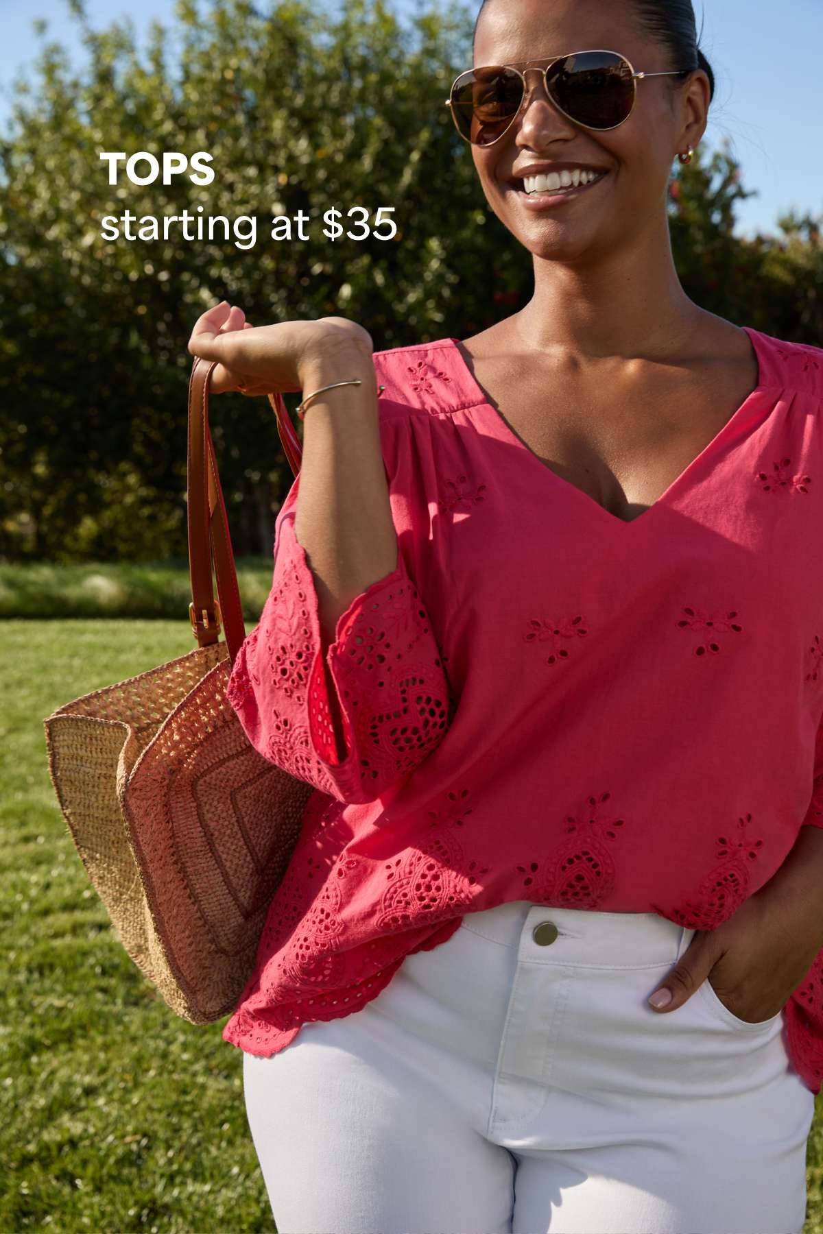 Woman outdoors wearing a bright pink top and holding a woven tote bag. Text reads “TOPS starting at $35.”