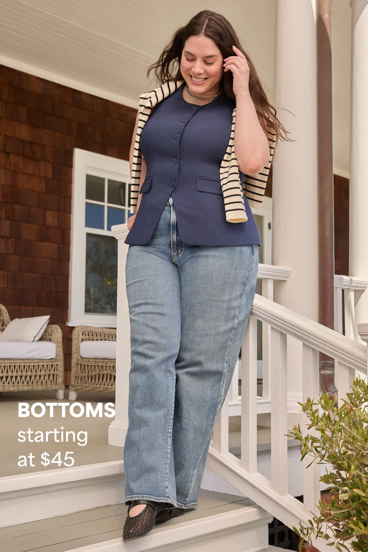 A woman models a navy top and wide-leg jeans with a striped sweater draped over her shoulders beside text that reads “BOTTOMS starting at $45.”