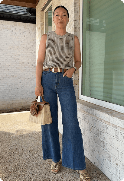 Rosa wearing a beige sleeveless top and jeans