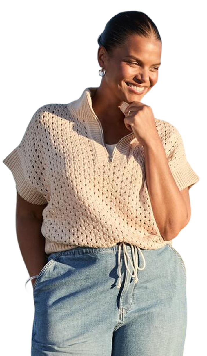 Woman wearing a light top and jeans while talking on a phone