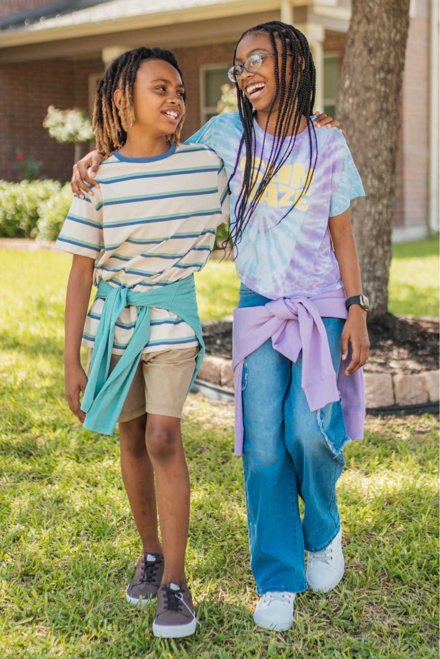 Models wearing Stitch Fix kids’ clothing including patterned girl’s dress, girl’s jean jacket, boy’s shirt and hoodie.