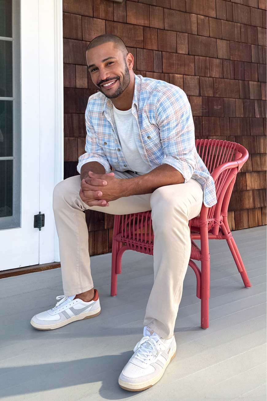 Model wearing Stitch Fix men’s clothing including green utility jacket, blue tee, and beige chinos.
