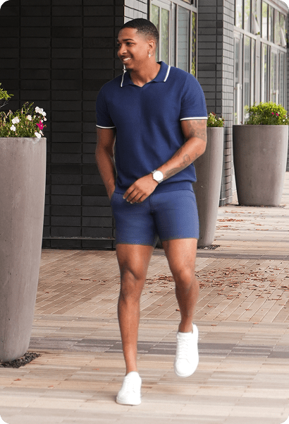 Cam wearing a navy polo and shorts