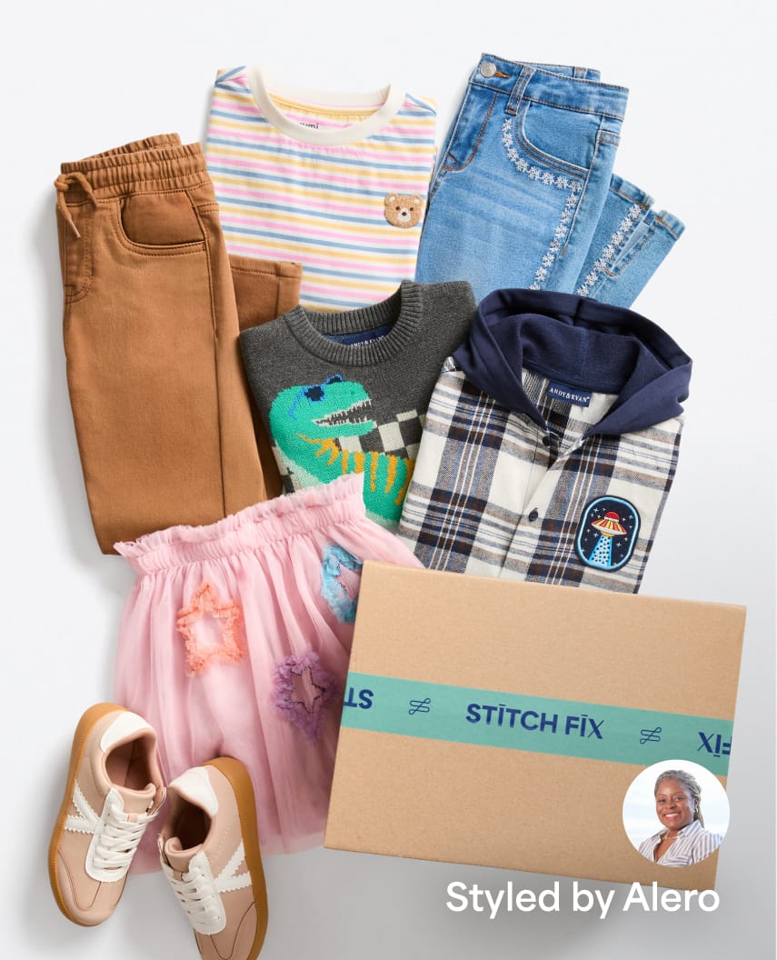 Flat lay of kids' clothes including brown pants, striped tee, dinosaur sweater, plaid hoodie, pink skirt, and shoes