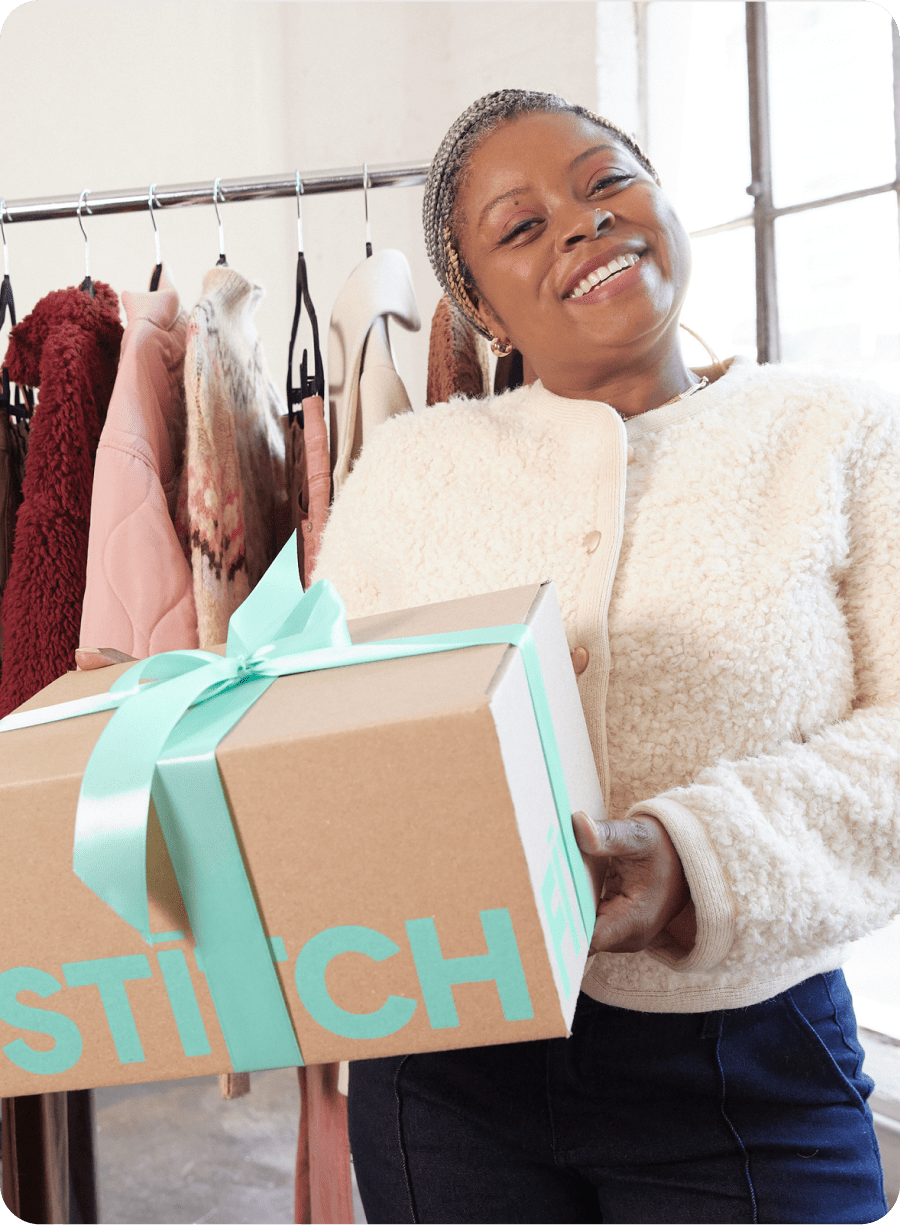 Two women Stylists, one in black floral dress, one in striped blouse and navy pants, holding Stitch Fix box