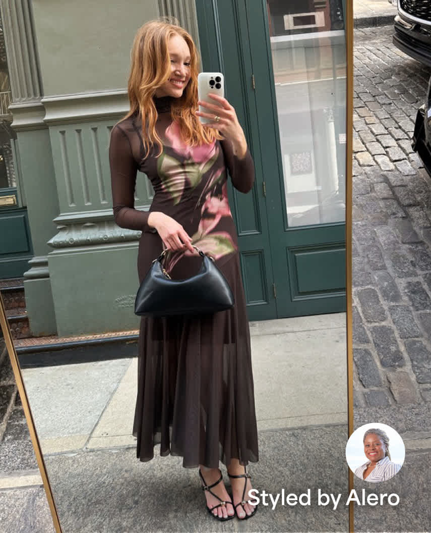 A woman models a light blue button-front maxi dress layered with a cream knit cardigan while taking a mirror selfie indoors. The image includes an outfit preview card with thumbs up and thumbs down icons and text that reads “Styled by Hailley.”
