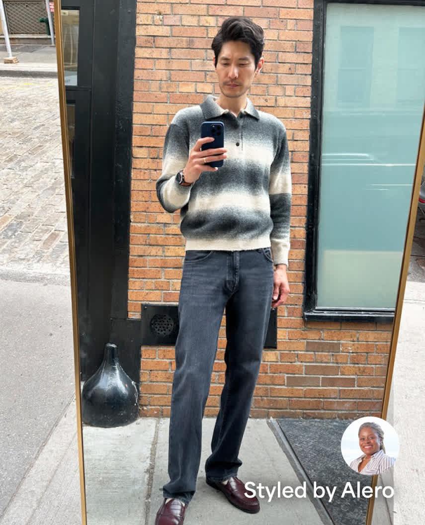 A full-length mirror selfie of a man posing on a city sidewalk wearing a striped grey-and-white polo sweater, dark grey straight-leg jeans, and burgundy dress shoes, labeled "Styled by Alero" in the bottom corner.