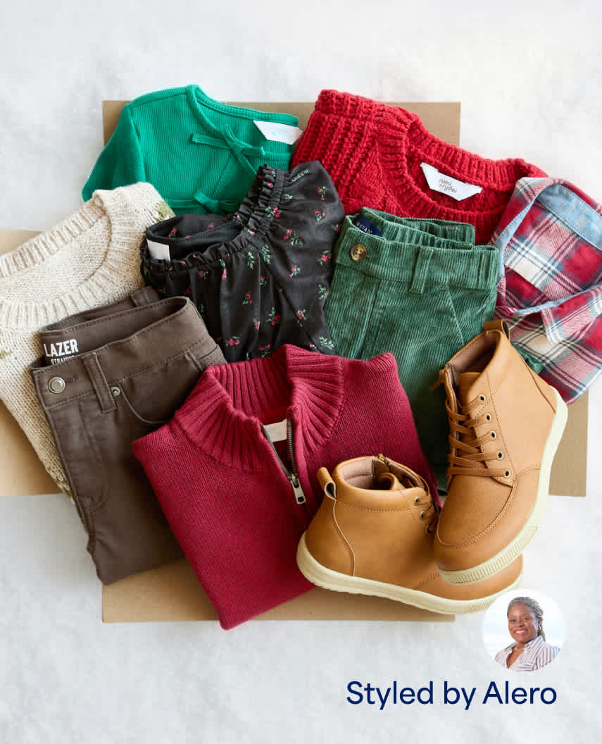 A flat-lay arrangement of kids' autumn clothing inside a Stitch Fix box, labeled "Styled by Alero". Items include a green polo sweater, red cable-knit sweater, brown pants, green corduroy pants, plaid shirt, cream sweater, and tan work boots.