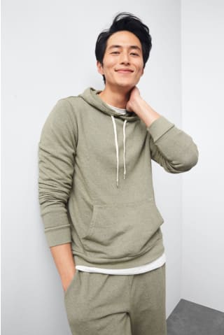 Model wearing Stitch Fix Mohnton Made mens olive green hoodie layered over a white t-shirt and matching jogger pants.