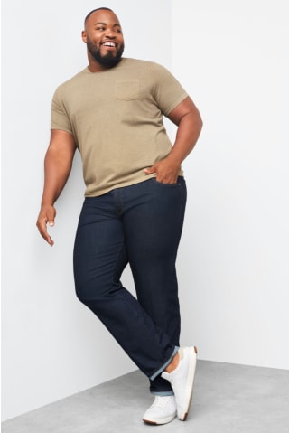 Model wearing Stitch Fix men’s Mohnton Made short sleeve green t-shirt with dark jeans and white sneakers.