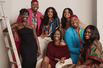 6 Stitch Fix Elevate designers sit and stand together as a group wearing brightly colored clothing