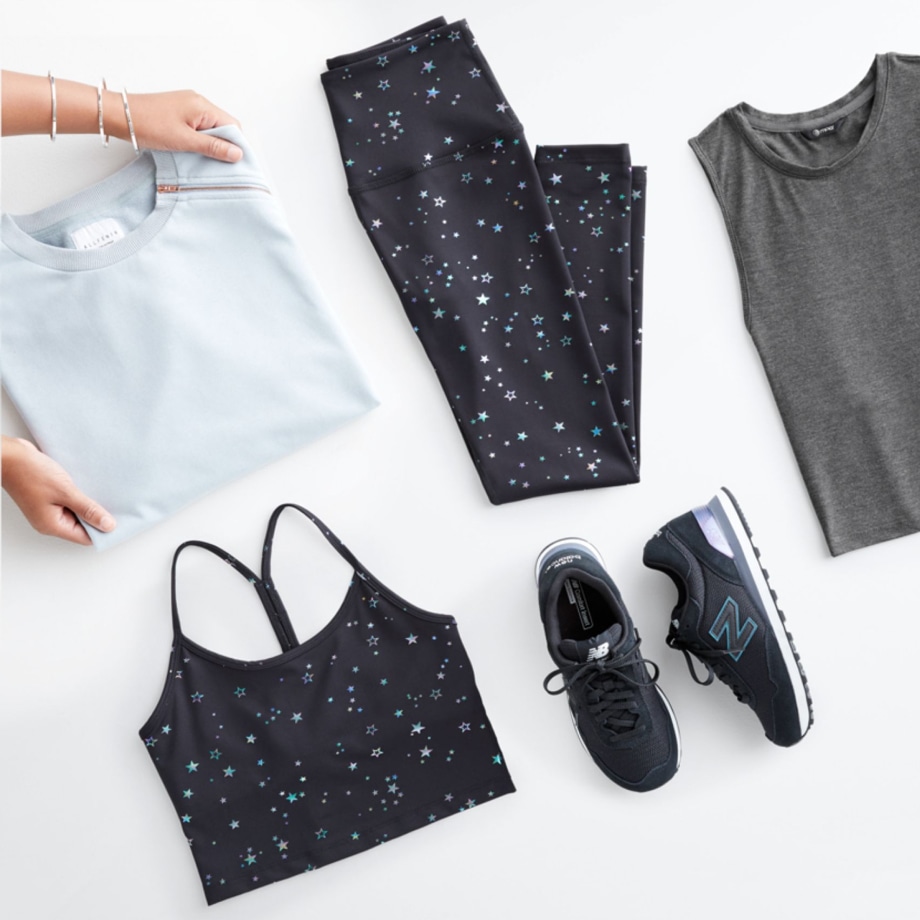 Folded Stitch Fix women’s clothes including yellow and white tops, blue tank and blue sandals.